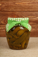 Jar of pickled small gherkin cucumbers on table