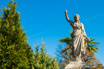 The sculpture of a woman with the anchor of hope on the Oakland Cemetery in sunny autumn day,...