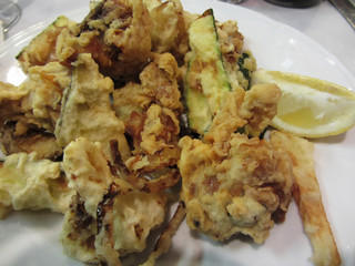 Breaded and fried crunchy vegetables with lemon slice . Battered onion rings, zucchini, potatoes and cauliflowers. Italian recipe