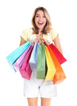 Excited young woman with shopping bags on white background
