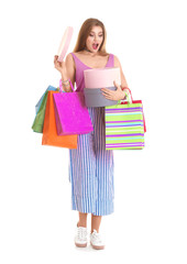 Excited young woman with shopping bags and boxes on white background