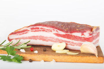 Bacon  decorated with garlic, pepper and rosebmary over white background