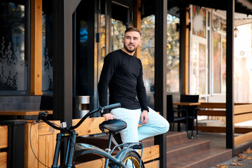 Fototapeta na wymiar Handsome young hipster man with bicycle outdoors