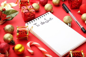 To do list in notepad with christmas decorations on red background