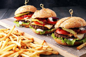 fresh tasty burger and french fries on wooden table
