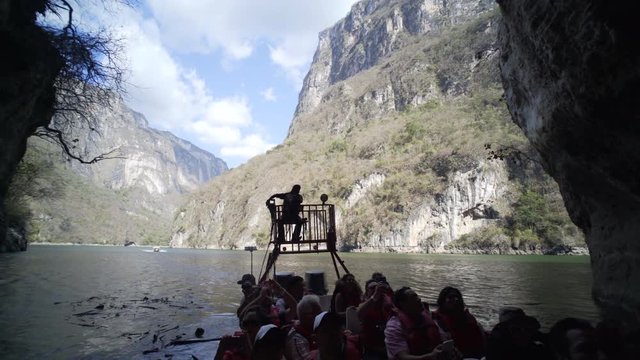 18 march 2017 Sumidero Canyon, Mexico. driving on boat,panoram out of canyon wall to turistic boat with silhouette of passengers, tour in the Canyon