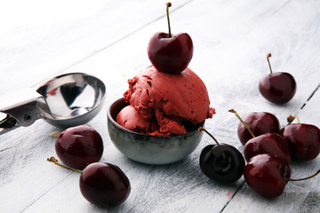 Homemade cherry ice cream on wooden background with fresh cherries