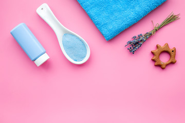 Skin care products for kids with lavender. Bottle, spa salt, towel and toy on pink background top view copyspace