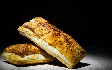 cake of puff pastry on wooden table against dark background with copy space.