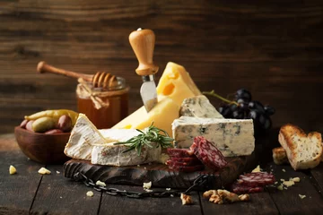 Gordijnen Assorted cheeses with grapes, nuts and rosemary © Belokoni Dmitri