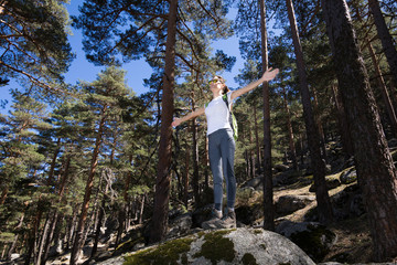 Naklejka na ściany i meble hiker sport woman standing on a great rock in the forest, open arms, in Navacerrada mountain, Guadarrama Natural Park, Madrid, Spain 