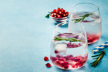 Pomegranate rosemary drink on light blue background. Selective focus, copy space. 