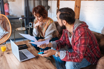 Mature couple sitting at home looking at their finance problems
