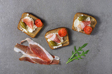 Sandwich with cheese,capers,ham on a gray background. The view from the top.