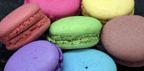 Colorful macarons on black granite table