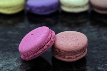 Colorful macarons on black granite table