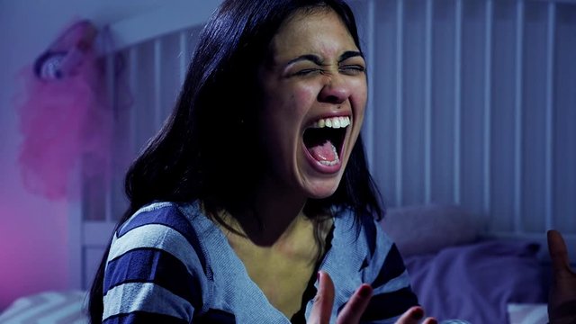Young hispanic woman screaming desperate in her room slow motion