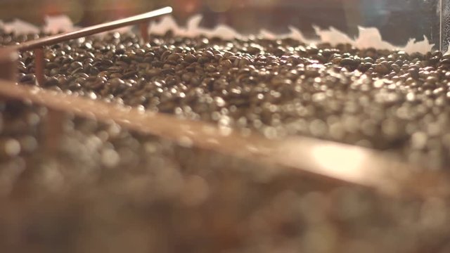 Processing of coffee beans.
Close-up. Focus in / focus out.
Fried coffee beans are mixed.