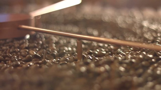 Processing of coffee beans.
Close-up. Horizontal ( from left to right ) pan.
Fried coffee beans are mixed.