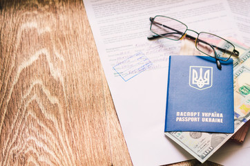 Ukrainian passport with documents and stamps and signs with dollars and hrivna
