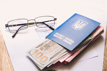 Ukrainian passport with documents and stamps and signs with dollars and hrivna