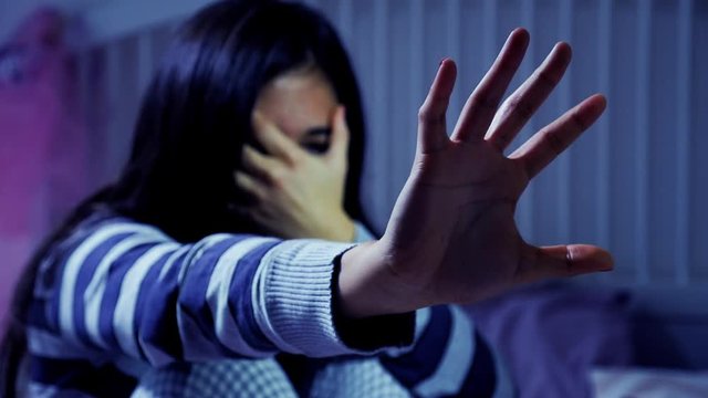 Concept of domestic violence at home on hispanic woman at night