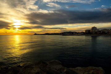 Sunset on the harbor of Sitges near Barcelona with buildings on the background.