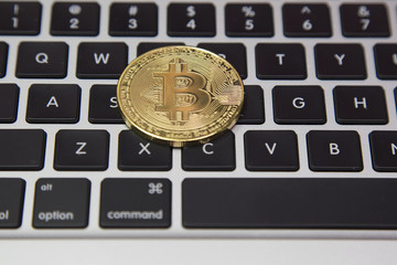 Bitcoin metal money with laptop keyboard