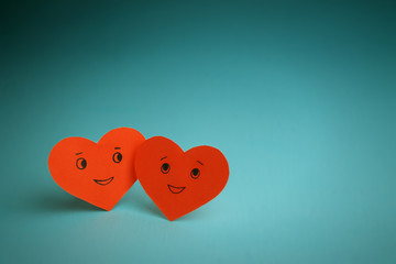 Two red smiling hearts on a blue background. St. Valentine's Day. Couple in love.