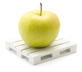 Apple (Smeralda variety) on a pallet isolated on white background one green yellow with blush.