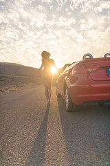 young woman in body with cabriolet at the road