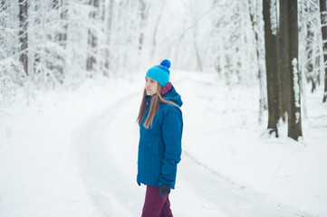 Beautiful girl walking in the winter forest