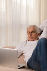 Fototapeta premium Mature man using laptop at home