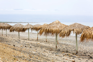 Fototapeta na wymiar Tropical parasols at Maleme beach on Crete, Greece