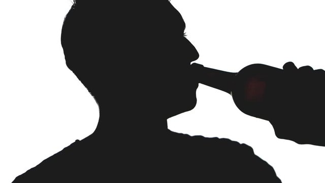 close up of silhouette man drinks alcohol a bottle. Young man drinks wine isolated on white background