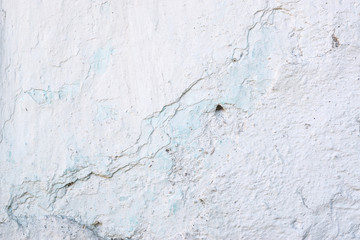 Closeup fragment of white shabby stone wall
