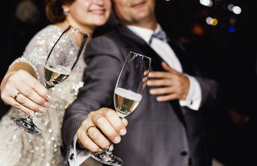 celebrating and toasting happy group of people with champagne at the wedding reception
