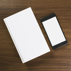 White book and smartphone on a desk