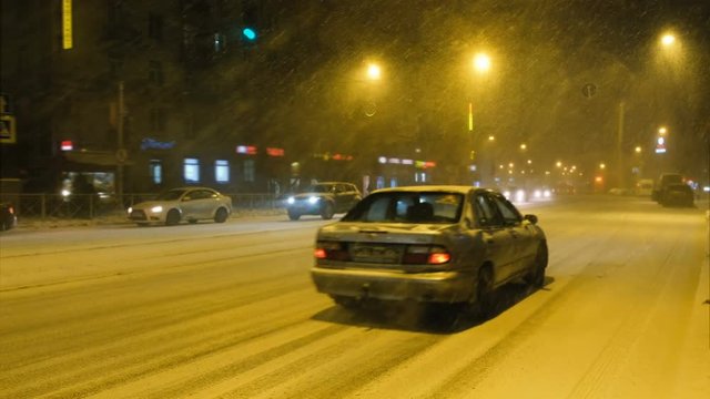 Snowstorm on the road in the city, cars go slowly, 4K.