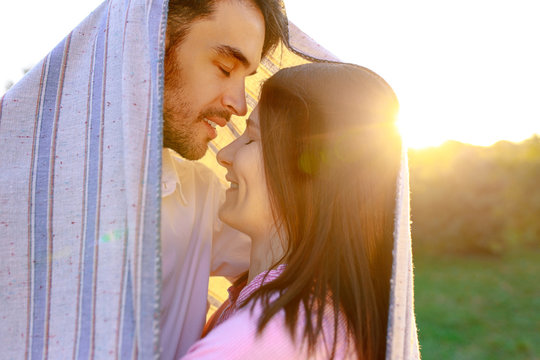 Happy couple portrait wrapped in a blanket 
