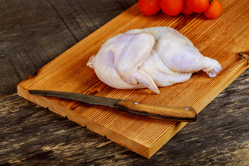 raw chicken meat with tomato on a wooden board