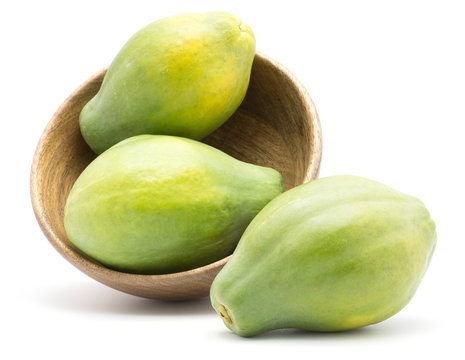 Green papaya (pawpaw, papaw) in a wooden bowl isolated on white background three whole fresh.