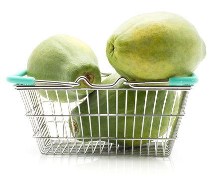Green papaya (pawpaw, papaw) in a shopping basket isolated on white background.