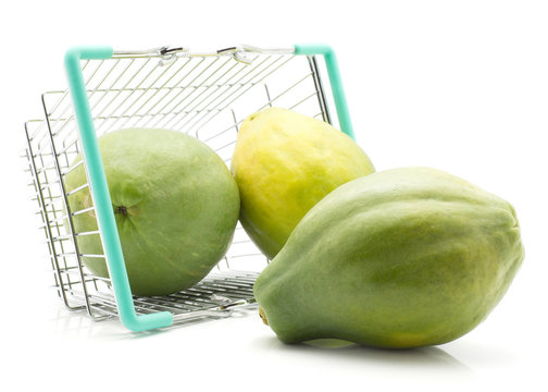 Green papaya (pawpaw, papaw) out a shopping basket isolated on white background three whole fresh.