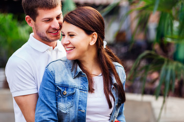 smiling pretty girl embraced by her beloved boyfriend