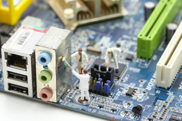 Miniature people : engineer and worker working on computer mainboard bitcoin concept.
