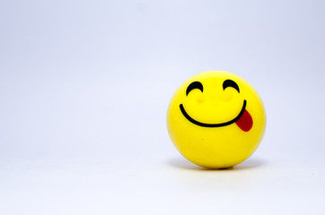 Yellow smiley showing tongue on a white background