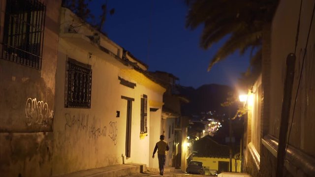 night colonial street view, man passing on street in ancient town  San Cristobal de las Casas