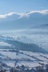 Rural alpine winter landscape with fence and path