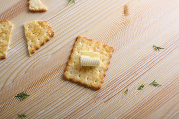 Cracker with butter on a wooden background